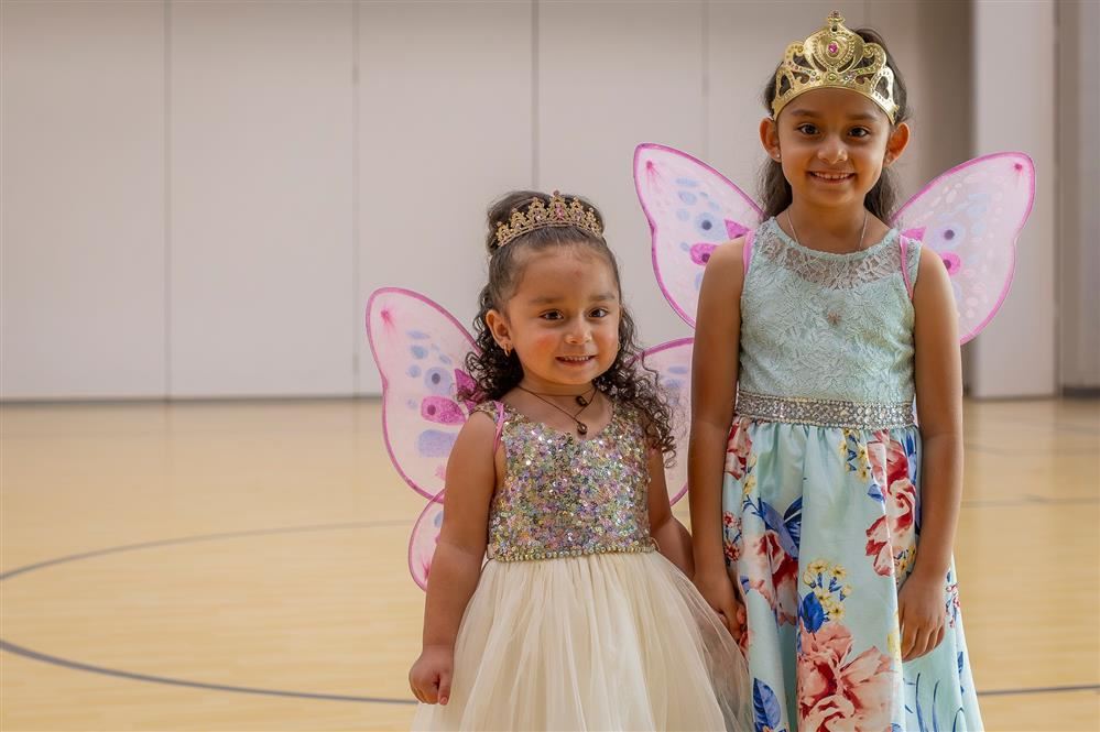 Two girls dressed in costumes and look like fairies. 